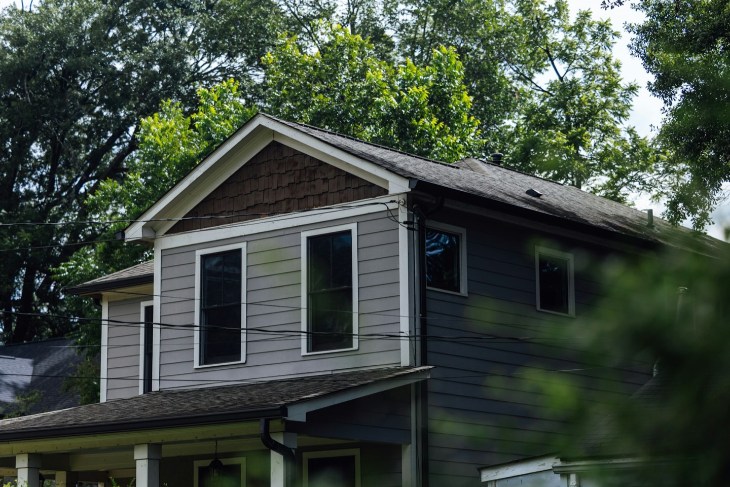 Gray lap siding with white trim and a shake-style gable