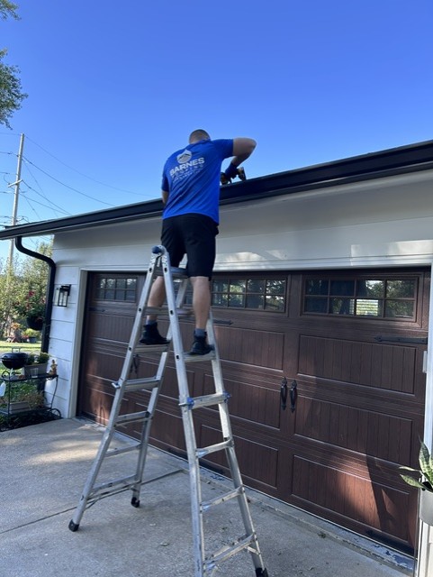 Barnes crew repairing a gutter from the ladder