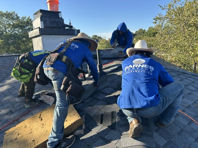 Barnes crew installing new shingles around the chimney
